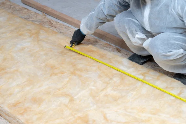 Professional roofer man installing thermal insulation rock wool under the roof — Stock Photo, Image