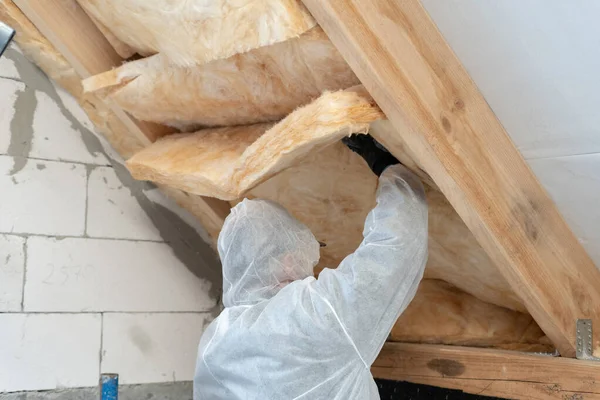 Profesyonel işçi çatının altına termal yalıtım katmanı yerleştiriyor. — Stok fotoğraf