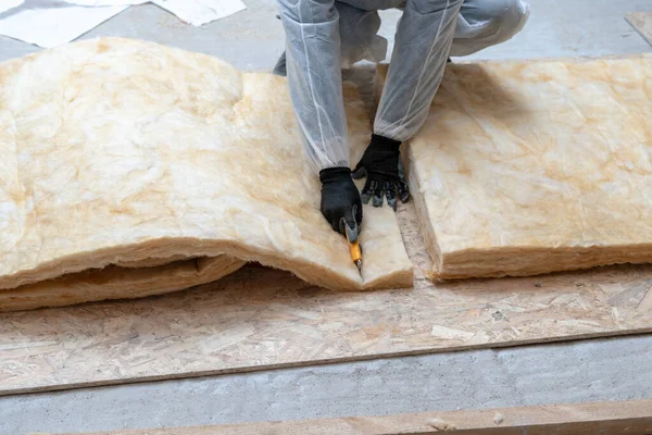 Professional worker man installing thermal insulation rock wool under the roof — Stock Photo, Image