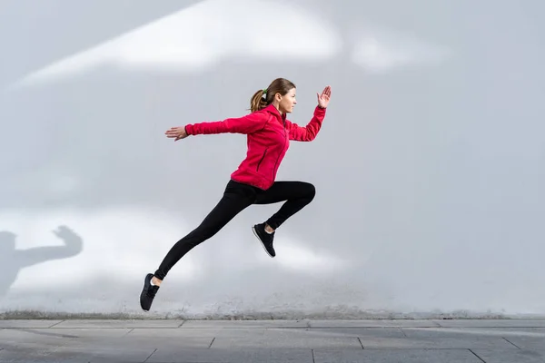 Jong volwassen meisje running outdoor in de stad — Stockfoto