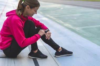 Genç ve sportif bir kız akıllı saat kullanıyor ve eğitimden sonra istifa ediyor.