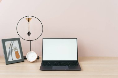 Serbest ve uzaktan çalışma konsepti. Pastel pembe duvarlı modern iç mekan, laptop bilgisayarına uzay görüntüsü ve ev ofisinin dekorasyonu.