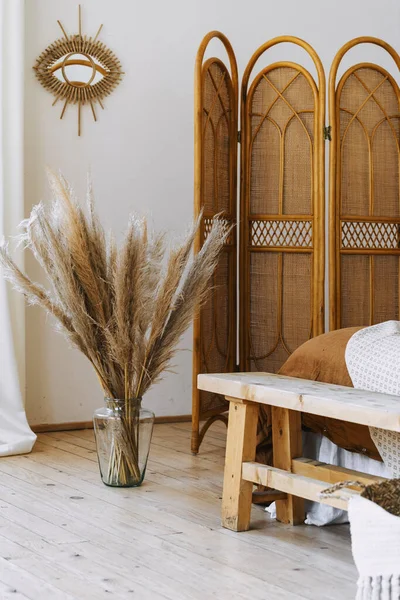 床边竹制屏风 家居装饰 花瓶中的干植物 白色墙壁上的镜子等舒适居室的垂直照片 — 图库照片
