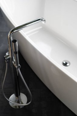 Tesisat elementleri kavramı. Modern iç tasarımı olan modern banyonun dikey yüksek açılı görüntüsü, yeni temiz ve boş banyo, duş başlığının yanındaki krom su musluğu