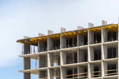 Kentsel yapı kavramı. Yeni modern binanın elementi, arka planda mavi fotokopi alanı gökyüzüne karşı şehirde güçlendirilmiş biçimlendirme ile birlikte inşa halindedir.