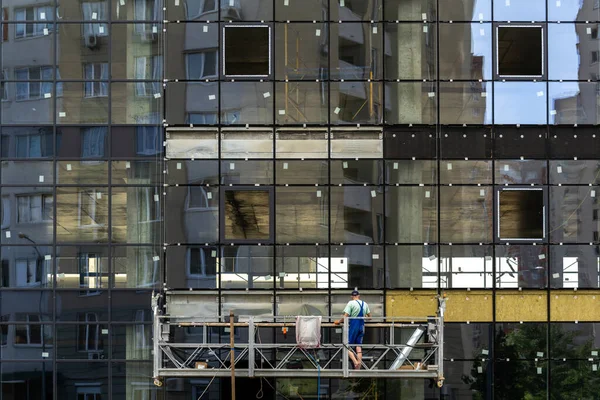 住宅開発の概念 足場設備のガラス窓と労働者との建設中の新しい建物のファサード — ストック写真