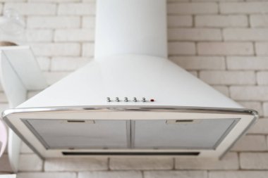 Modern yemek pişirme kaputu tuğla duvara karşı. Çağdaş mutfak elementi. Beyaz iç mekan.