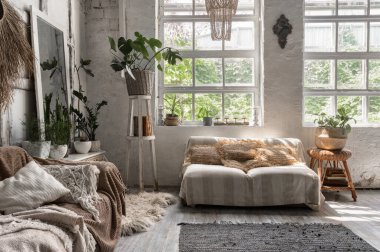 Rahat bir evde, kanepede, yastıklarda, yumuşak ekoseli, ev dekorasyonunda ve klozetin yanındaki çiçek saksılarında yeşil bitkilerde şık iç tasarımı olan salon odası.