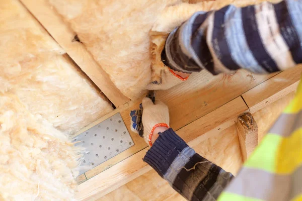 正在建设的建筑物的概念 新屋天花板手握刀具 切割岩棉保温材料专业工人的剪影 — 图库照片