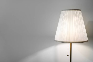 Aydınlanma evi kavramı. Beyaz zemin lambası boş ve arka plan duvarının fotokopisi modern oturma odasında minimalist iç mekan ile duruyor.