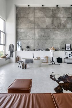 Çağdaş banyo, beton zemin, ev dekorasyonu, havlu, bornoz. Çağdaş iç mekanı olan oturma odası, deri kanepe, puf, beton zeminde halı ve uzay duvarının kopyası.