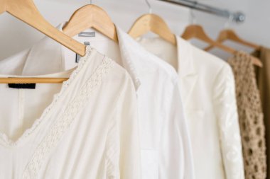 Modern ve açık gardırobun seçici odağı giyinme odasında askıda şık kadın kıyafetleri.