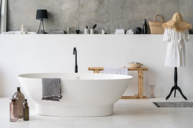 Modern apartmandaki beyaz modern banyonun önü şık bir iç dekorasyon, ev dekorasyonu, pamuklu bornoz ve temiz kuru havlular.