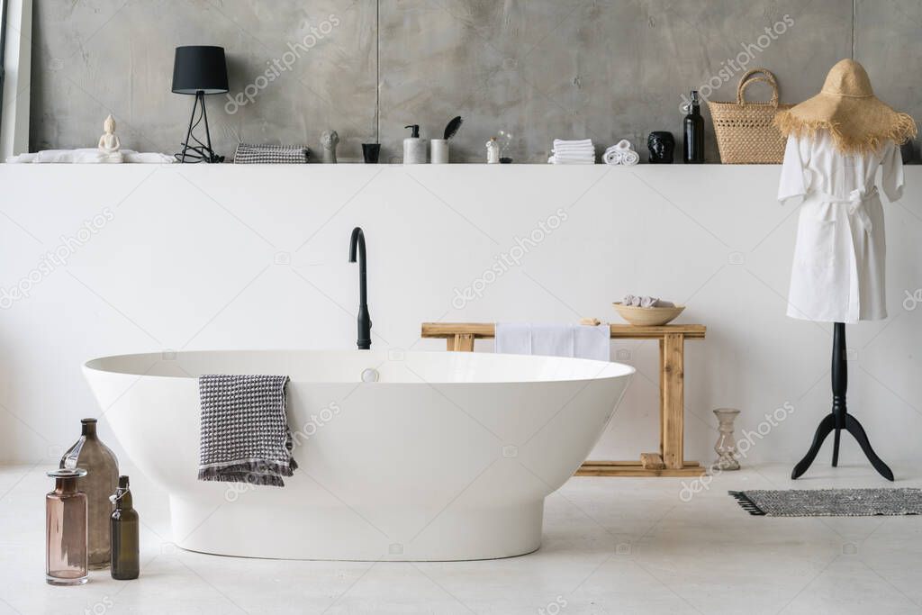 Front view of white modern bath in contemporary apartment with stylish loft interior design, house decor, cotton bathrobe and clean dry towels