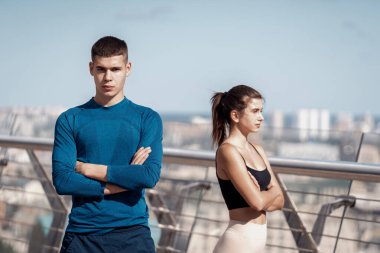 Takım çalışması aktivite konsepti. Kameraya bakan kendine güvenen genç sporcu ellerini göğsüne koydu. Açık hava spor eğitiminden sonra arkadaşlarıyla arka planda bulanık duran bir adam