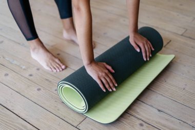 Sabah ve hafta sonu egzersizi kavramı. Yüksek açı, genç Afro-Amerikan kadının fotokopi odasında yoga minderi tutmasını evde antrenman yapmasını spor egzersizi yapmasını engelledi.