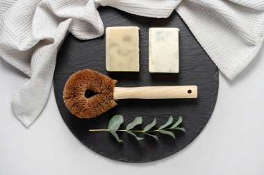 Çevre dostu ve biyolojik olarak bozunabilir nesneler kavramı. Düz yatıyordu, hindistan cevizi fırçasının üst görüntüsü, katı deterjan sabunu, havlu ve okaliptüs bitkisi siyah plaka üzerinde beyaz fotokopi alanı arka planına karşıydı