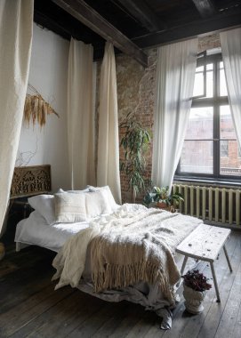 Şık bir yatak odası yumuşak çarşaflar, sıcak atış ve eşsiz dekorlarla süslenmiş rahat bir yatak odası. Doğal ışık geniş pencerelerden süzülerek sakin bir atmosfer yaratır..