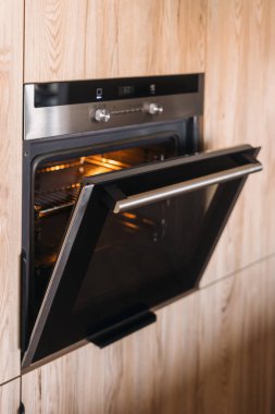 Modern bir mutfakta sergilenen cam kapaklı parlak bir fırın modern bir dairedeki minimalist tasarımı yansıtıyor. Ev aletleri ve ev aletlerinin yakın çekim görüntüleri.