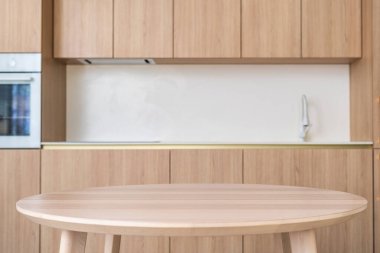 Çağdaş bir mutfak, şık ahşap dolaplar ve yemek masası içeriyor ve kahvaltı odasında yaşamak için sıcak ve davetkar bir alan yaratıyor. Arkaplanda samimi bir iç mekan