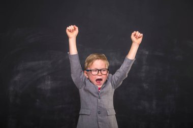 Okul üniformalı küçük süper kahraman çocuk. Gözlüklü mutlu çocuk eğitime hazır..