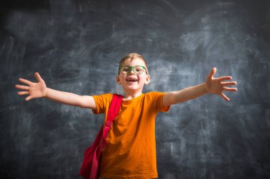 Çantalı çocuk. Akıllı küçük çocuk tahtaya karşı