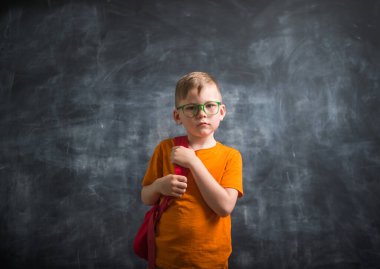 Çantalı çocuk. Akıllı küçük çocuk tahtaya karşı