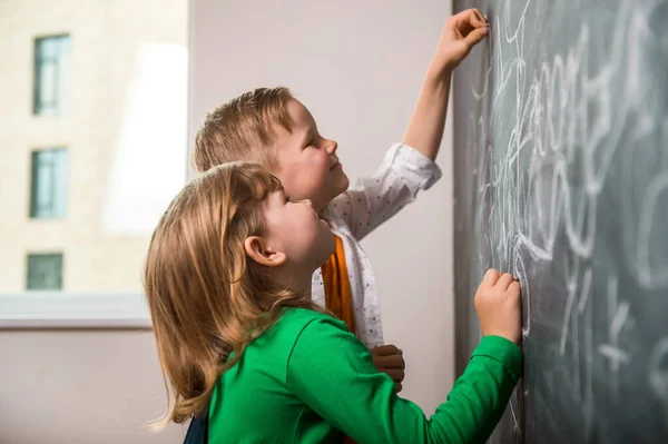 小孩子在黑板上写字 快乐的孩子数数和画数字 回学校去 — 图库照片