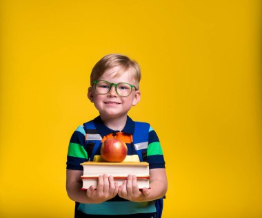 İlkokul çocuğu. çocuk Whit kitabı ve elma ellerinde..