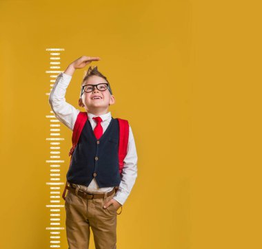 Etkilenmiş çocuğun boy boy boy fotoğrafı kol ölçüsünü yükselt beklenmedik haberler aç ağız aç moda moda kıyafetleri pastel arka planda izole edilmiş.