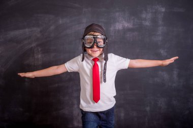 Çocuk rüyası pilot olmak. Okula dönelim. Genç iş adamının portresi kanatları oluşturur. Başarı, yaratıcılık ve başlangıç konsepti. Metnin için boşluk kopyala.