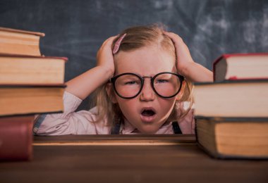 Hüsrana uğramış çocuk ev ödevi yapıyor. Okula dönelim. Komik çocuk suratı. Zor ve sıkıcı eğitim