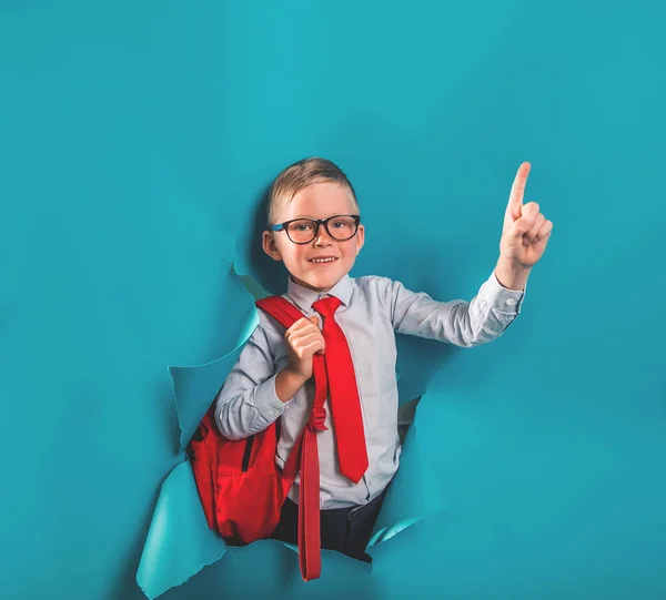 Gelukkige Lachende Jongen Uniform Breken Blauwe Papieren Muur Verrast Kind — Stockfoto