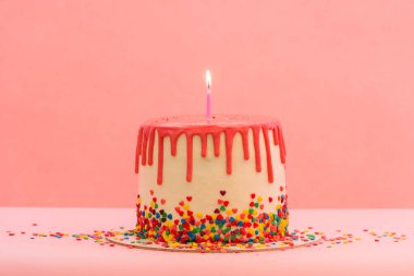 Tek mumlu büyük pasta. Mutlu doğum günü mumları. Pembe arka planda kırmızı çikolata süslemeli pasta. Parlak mumlar. İyi ki doğdun Tatlı ve lezzetli tatlı..