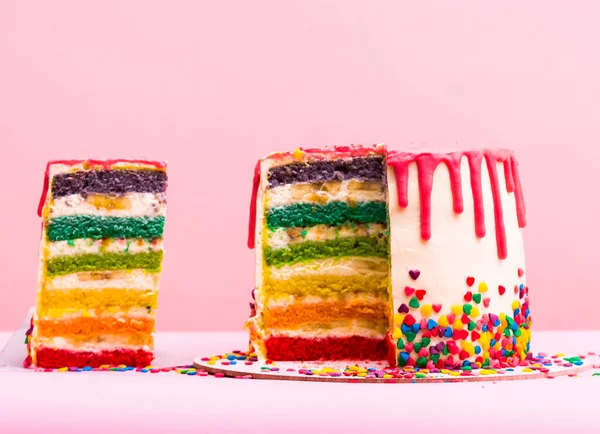 rainbow cake. Bright different colors of layers. unusual cake. A layer of caramel sponge cake successfully emphasizes. The pastry chef cut the cake