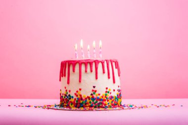 Pembe arka planda beş doğum günü mumu. Pembe arka planda pembe çikolata süslemeli kek. Beş mum. İyi ki doğdun Tatlı ve lezzetli bir tatlı. Kız doğum günü partisi.