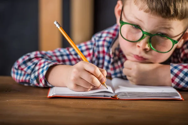 学校の仕事に専念する男子生徒 — ストック写真