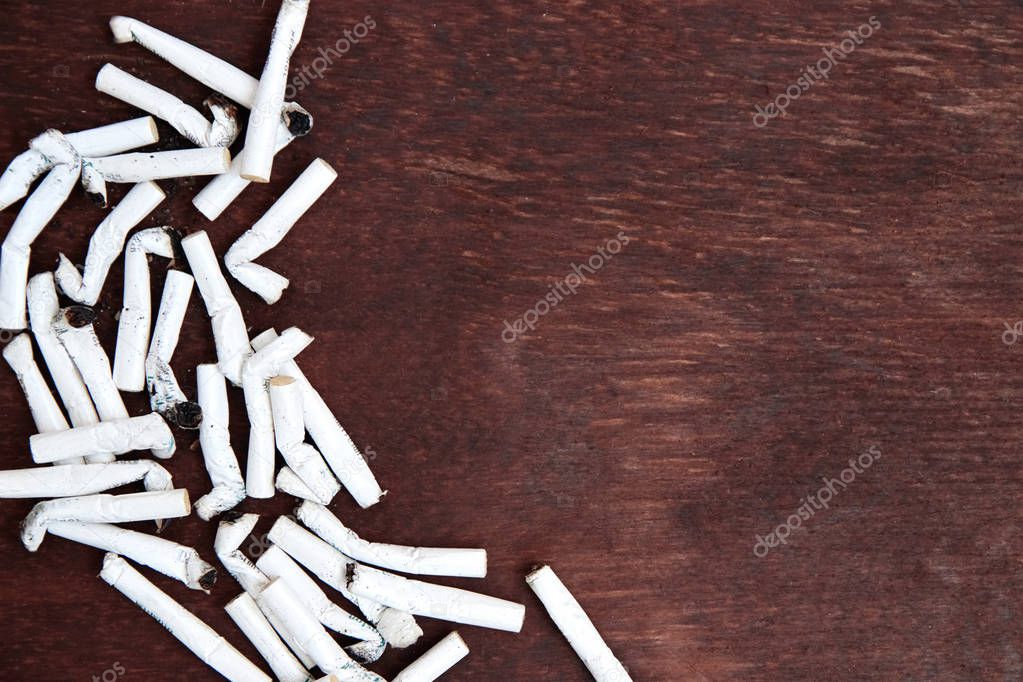 Cigarette butts on wood background. Smoking is bad for your health. Copy space. Top view.