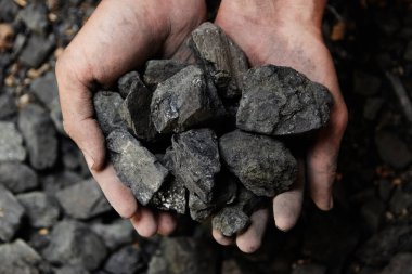 Madenci kömür arka plan adam elinde. Kömür madenciliği veya enerji kaynağı, çevre koruma. Endüstriyel kömürler. Volkanik kayalar.