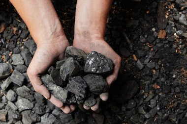 Madenci kömür arka plan adam elinde. Kömür madenciliği veya enerji kaynağı, çevre koruma. Endüstriyel kömürler. Volkanik kayalar.