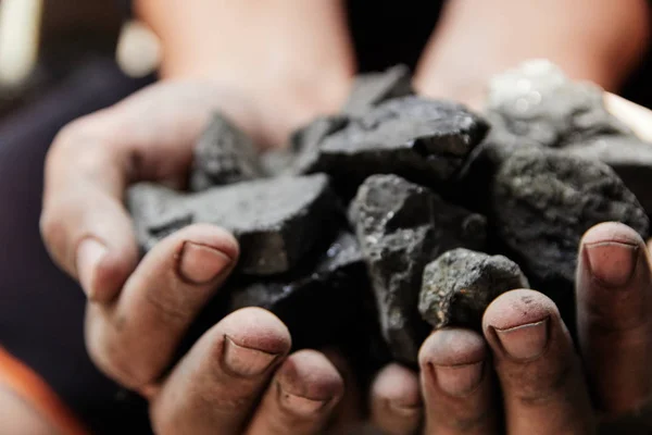 Coal miner in the man hands of coal background. Coal mining or energy source, environment protection. Industrial coals. Volcanic rock.