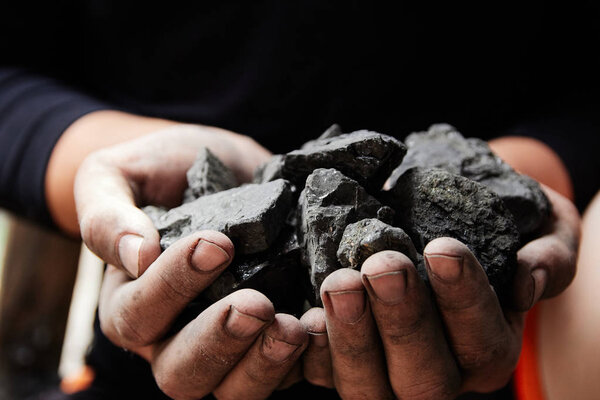 Coal miner in the man hands of coal background. Coal mining or energy source, environment protection. Industrial coals. Volcanic rock.