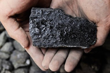 Madenci kömür arka plan adam elinde. Kömür madenciliği veya enerji kaynağı, çevre koruma. Endüstriyel kömürler. Volkanik kayalar.