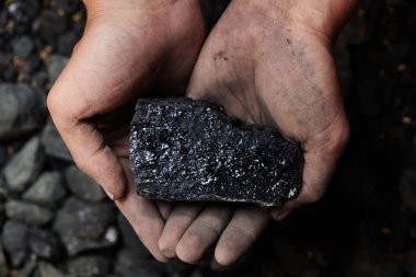 Madenci kömür arka plan adam elinde. Kömür madenciliği veya enerji kaynağı, çevre koruma. Endüstriyel kömürler. Volkanik kayalar.