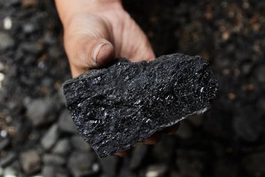 Madenci kömür arka plan adam elinde. Kömür madenciliği veya enerji kaynağı, çevre koruma. Endüstriyel kömürler. Volkanik kayalar.
