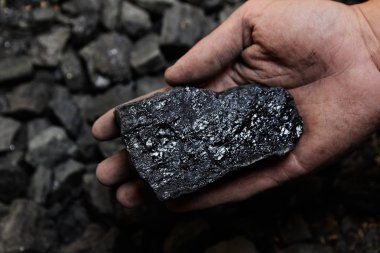 Madenci kömür arka plan adam elinde. Kömür madenciliği veya enerji kaynağı, çevre koruma. Endüstriyel kömürler. Volkanik kayalar.