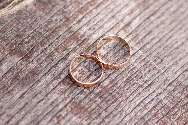 Two golden wedding rings on wood background