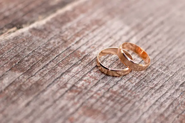 Ahşap arka plan üzerinde iki altın alyans