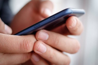 Erkek el bir cep telefonu tutan ve sms yazma