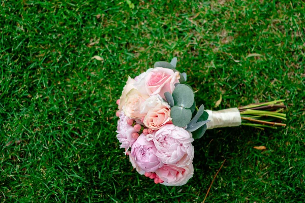 Agradável e bonito buquê de casamento de flores na grama verde — Fotografia de Stock